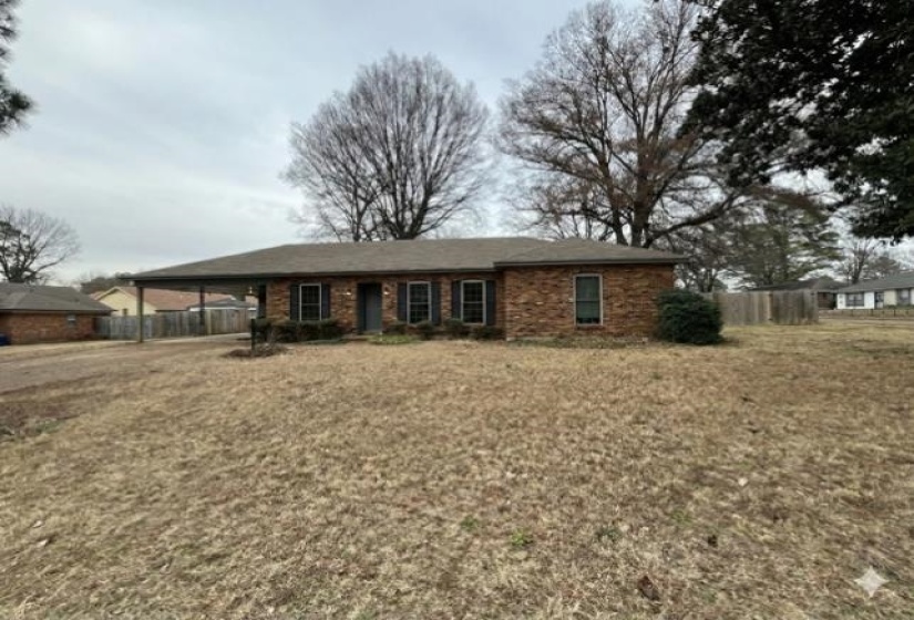 Ranch-style home featuring a carport and brick siding