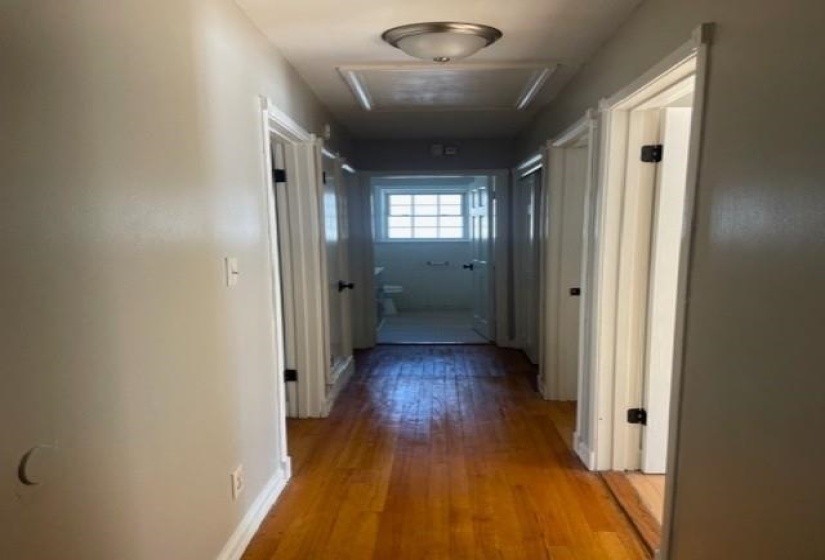 Corridor with hardwood / wood-style flooring and attic access