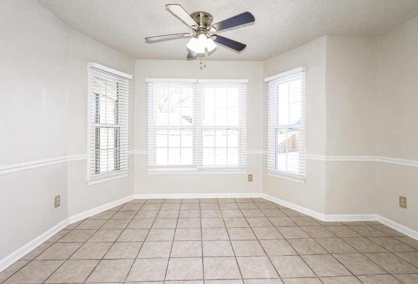 Spare room with a textured ceiling, light tile patterned floors, and a ceiling fan