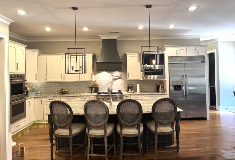 Kitchen with crown molding, built in appliances, Nail down hardwood flooring all thru out downstairs, recessed lighting, and Tile backsplash Under cabinet lighting and under floor cabinets too   ALL Appliances stay including both laundry rooms