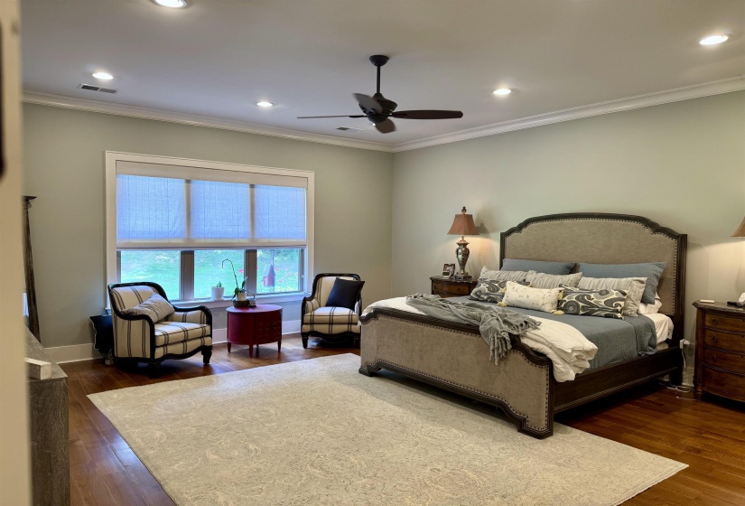 Large bedroom with nail down hardwood and beautiful exterior back view of property