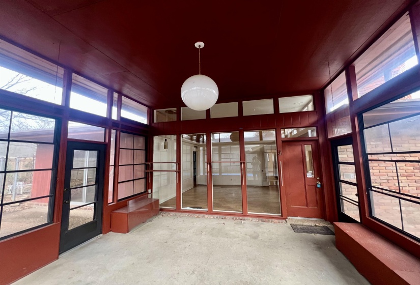 Unfurnished sunroom featuring unfinished concrete floors