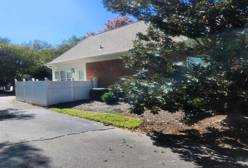 View of property exterior with brick siding and a shingled roof