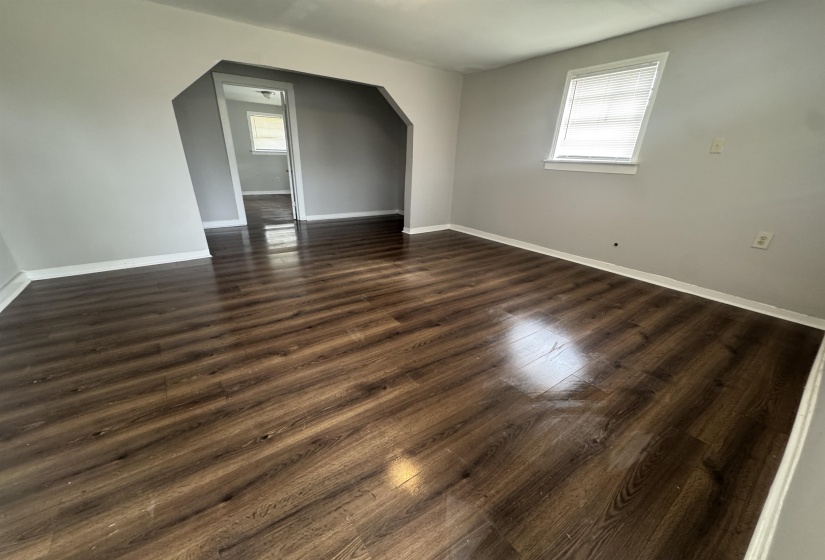 Bonus room featuring arched walkways and dark wood-style floors