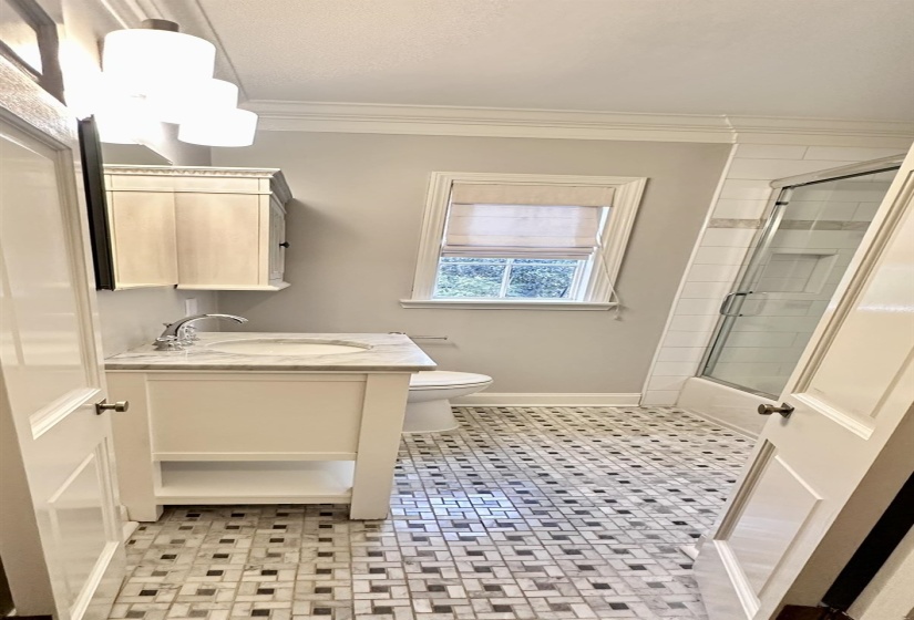 Full bathroom featuring vanity, ornamental molding, bath / shower combo with glass door, and light tile patterned floors