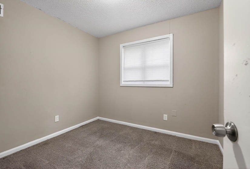 Unfurnished room featuring a textured ceiling and carpet flooring