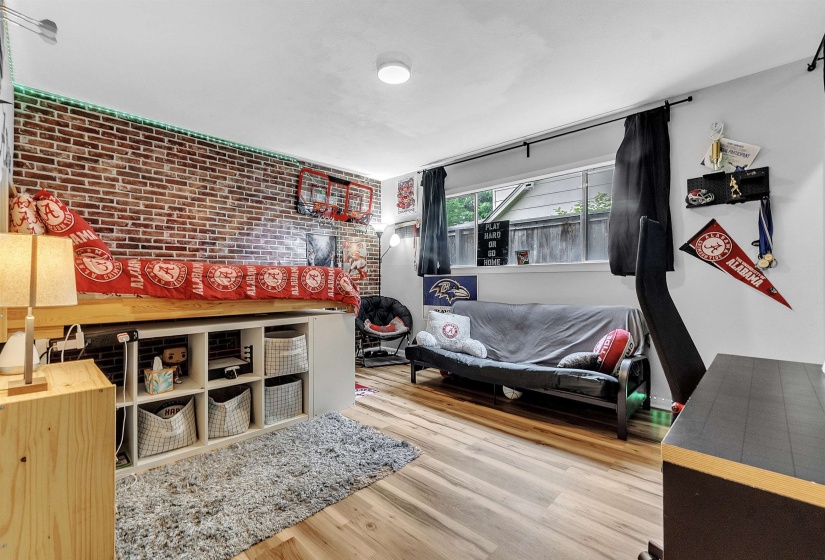 Bedroom featuring wood finished floors and brick wall