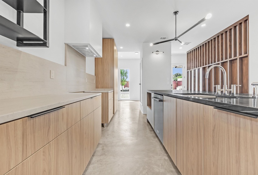 Kitchen with modern cabinets, light brown cabinets, recessed lighting, concrete floors, and backsplash