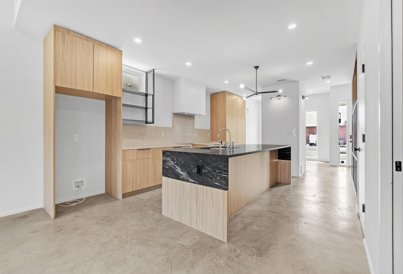 Kitchen with modern cabinets, light brown cabinets, a sink, and recessed lighting