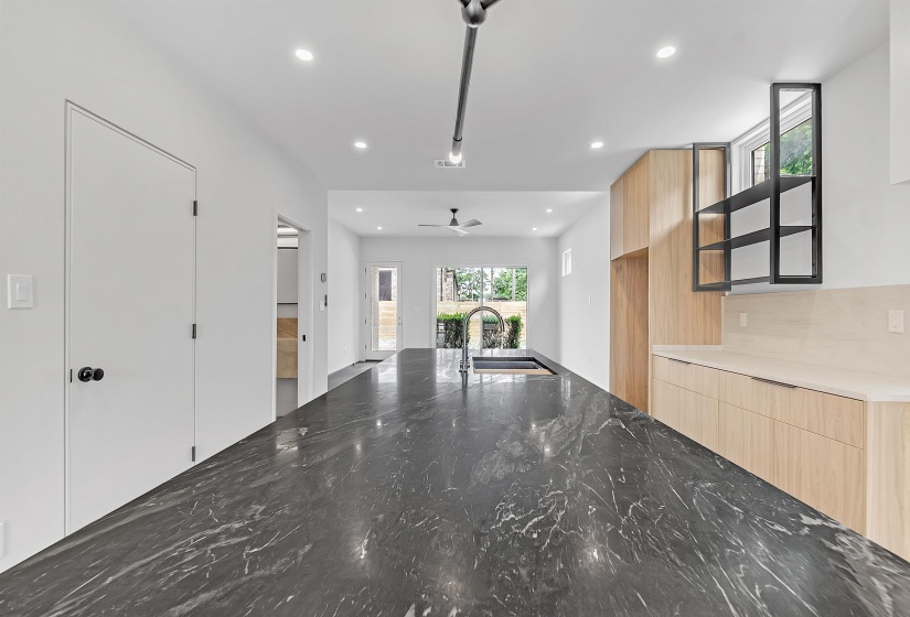 Kitchen with a sink, modern cabinets, light brown cabinetry, recessed lighting, and ceiling fan