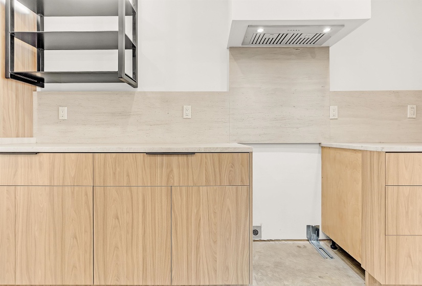 Kitchen featuring modern cabinets, light brown cabinetry, light countertops, and recessed lighting