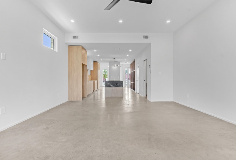 Unfurnished living room with ceiling fan, plenty of natural light, recessed lighting, finished concrete floors, and baseboards