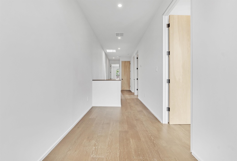Corridor with light wood finished floors, recessed lighting, and baseboards