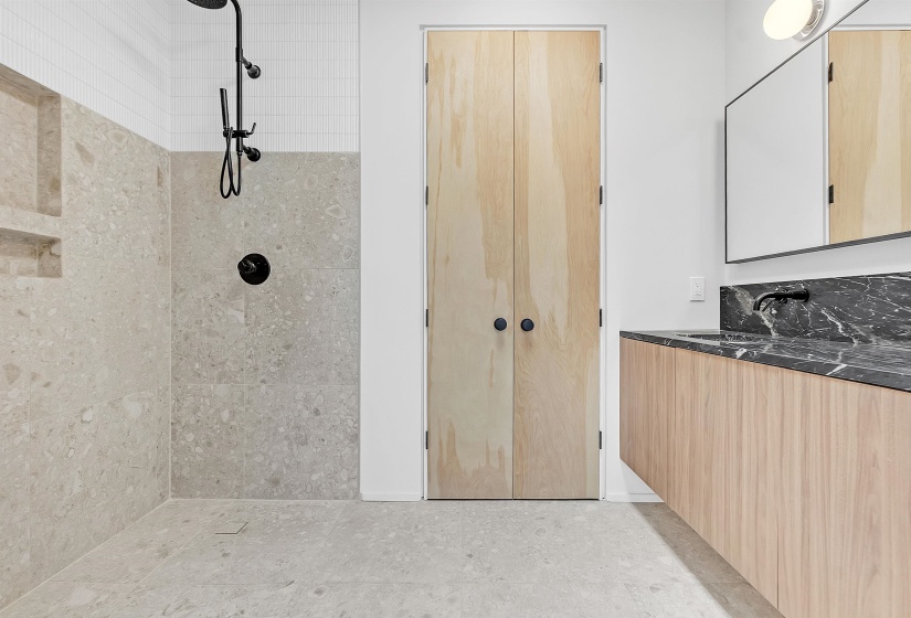 Bathroom featuring a tile shower and vanity
