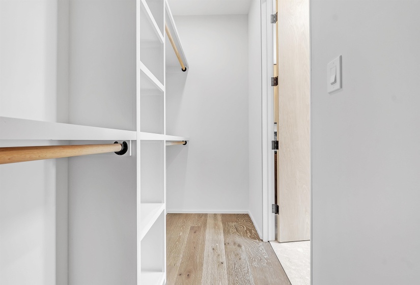Walk in closet with light wood finished floors
