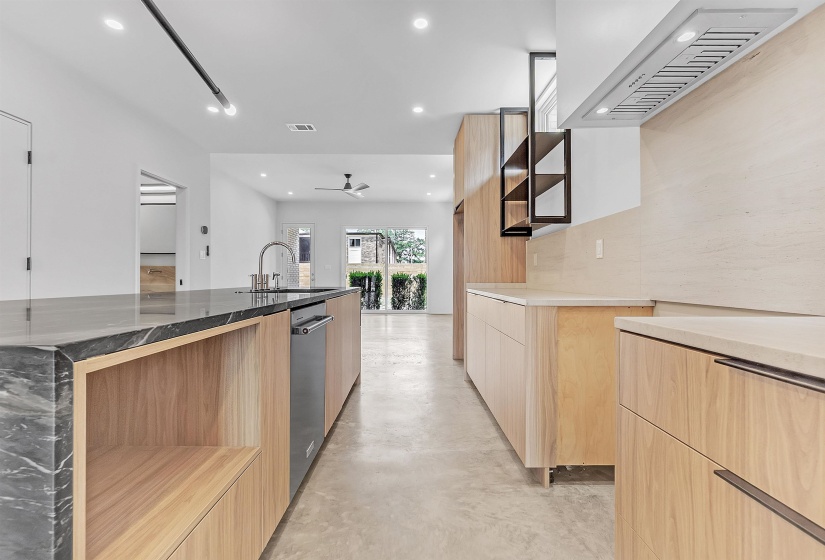 Kitchen with modern cabinets, custom range hood, light brown cabinets, a sink, and recessed lighting
