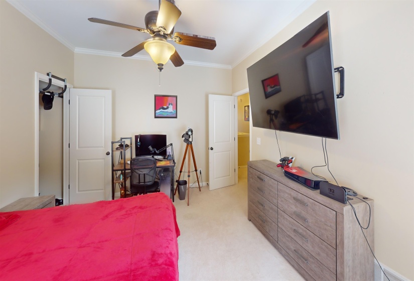 Bedroom featuring light carpet, crown molding, and a ceiling fan