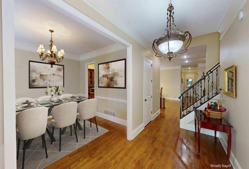 Dining room with a chandelier, crown molding, wood finished floors, and stairs