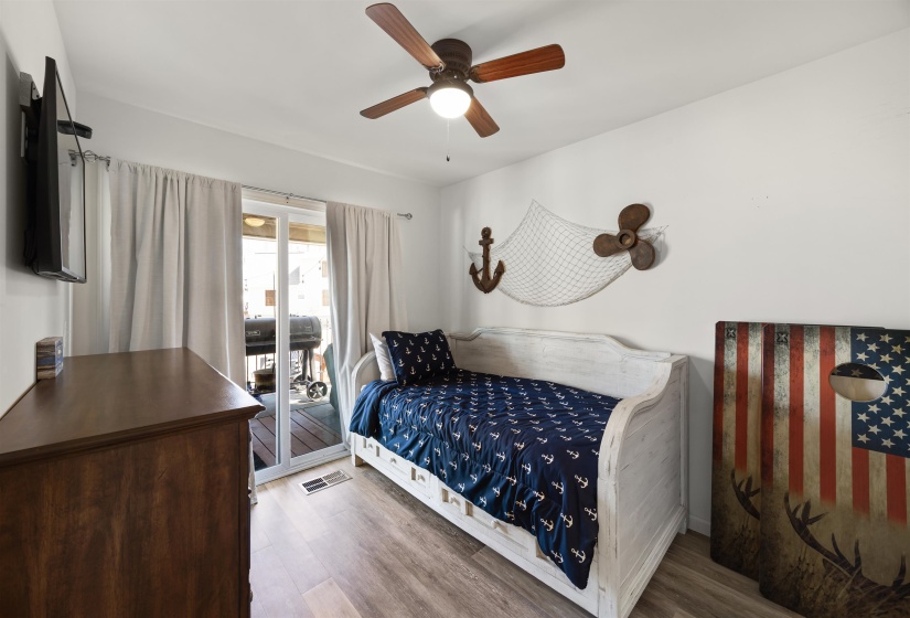 Bedroom with ceiling fan, visible vents, and wood finished floors