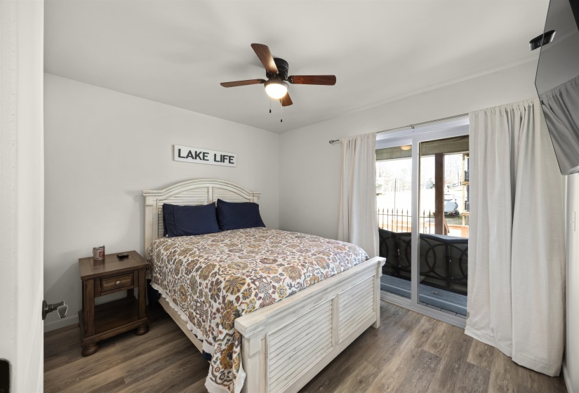 Bedroom with a ceiling fan, baseboards, access to exterior, and wood finished floors