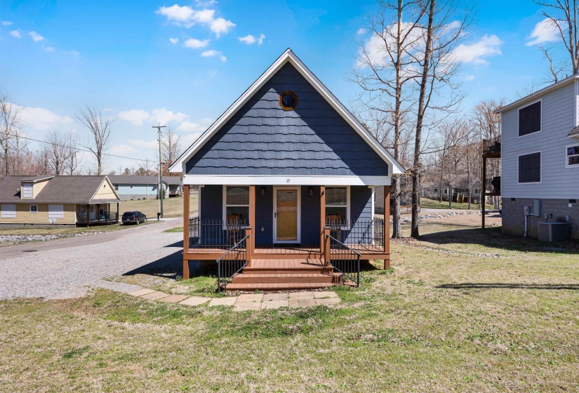 Back of house with a porch, central air condition unit, and a lawn