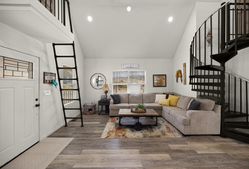 Living room featuring recessed lighting, high vaulted ceiling, stairway, and wood finished floors