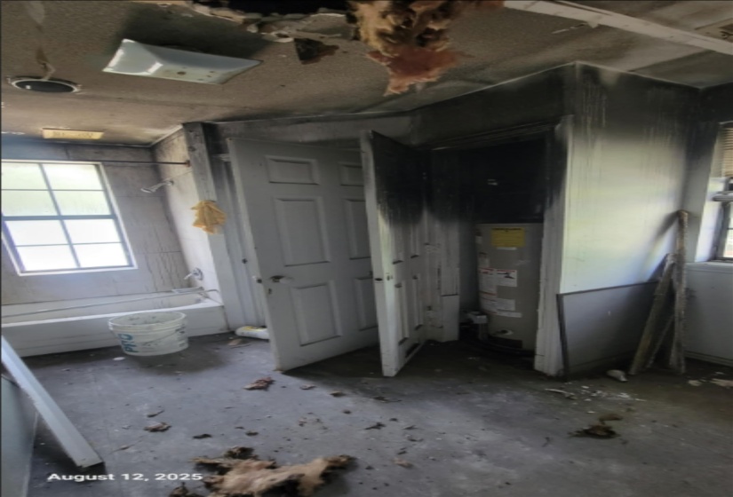 Full bath featuring washtub / shower combination and water heater