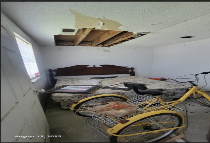 Bedroom with unfinished concrete floors and a textured ceiling