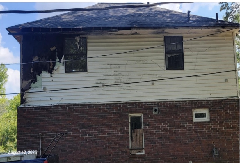 View of side of home with brick siding and roof with shingles