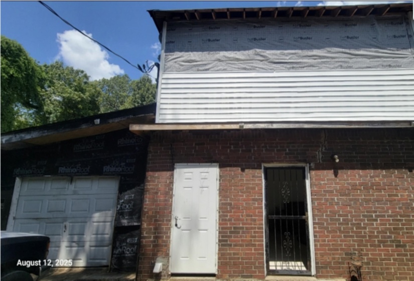 View of home's exterior featuring a garage and brick siding