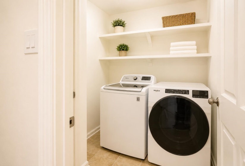 Dedicated laundry area featuring a top-load washing machine and a front-load dryer
