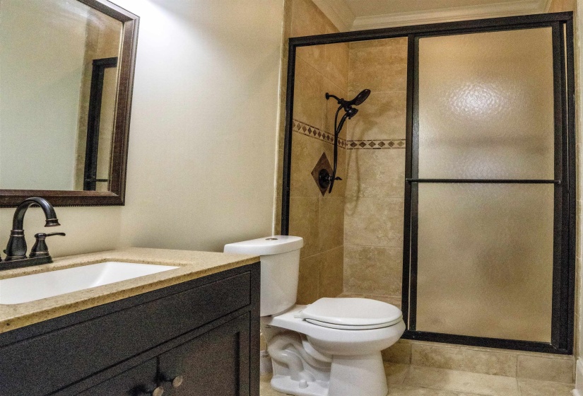 Bathroom featuring vanity, toilet, an enclosed shower, and tile patterned floors