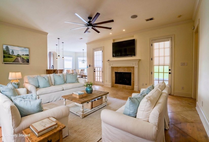 Living room with visible vents, ceiling fan, ornamental molding, and a fireplace