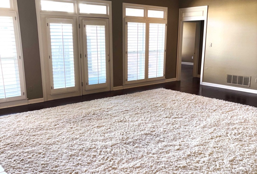 Bedroom featuring dark wood-style floors and multiple windows