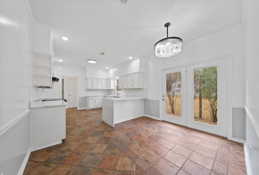 Kitchen featuring white cabinetry, a peninsula, recessed lighting, backsplash, and light stone countertops