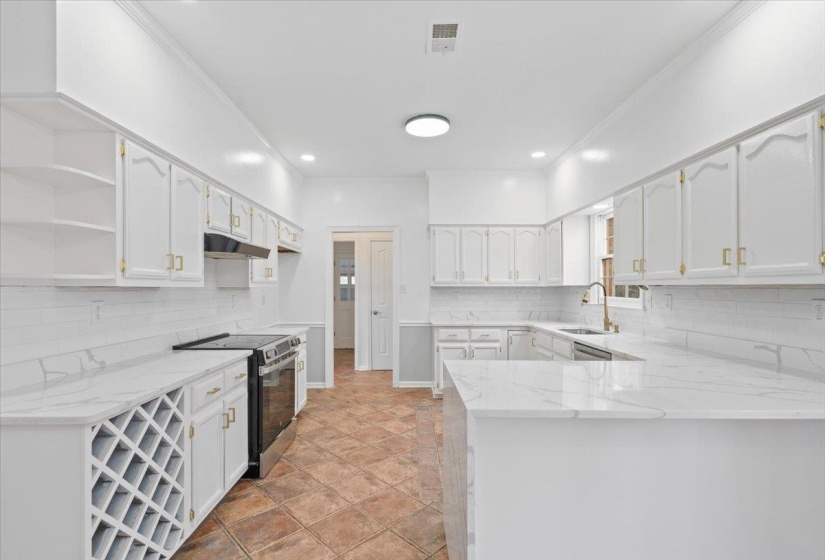 Kitchen with light stone counters, crown molding, stainless steel electric range oven, decorative backsplash, and open shelves