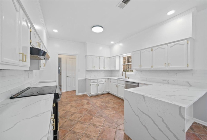 Kitchen featuring light stone counters, range with electric stovetop, white cabinets, decorative backsplash, and crown molding
