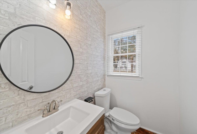 Bathroom featuring vanity and brick wall