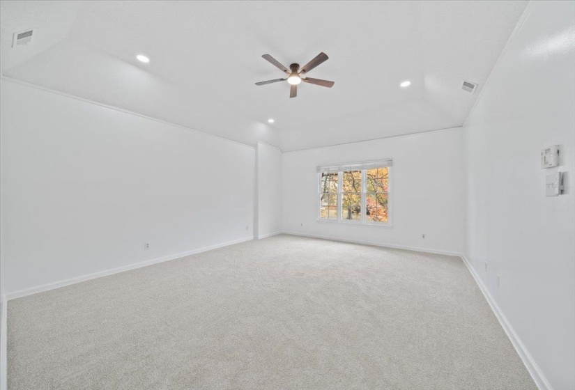 Spare room with light carpet, a ceiling fan, vaulted ceiling, and recessed lighting