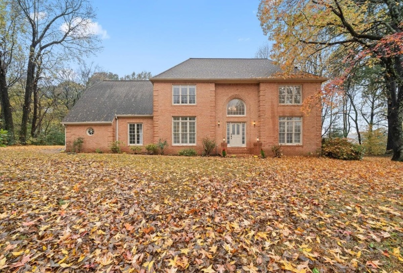 Colonial-style house with brick siding and roof with shingles