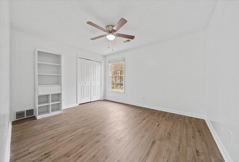 Unfurnished bedroom with light wood-type flooring, ceiling fan, a closet, and a textured ceiling