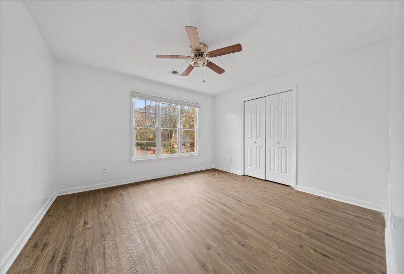 Unfurnished bedroom with wood finished floors, a closet, ceiling fan, and a textured ceiling
