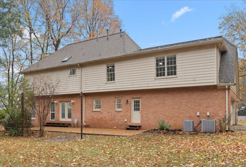 Back of property featuring entry steps, a patio, and brick siding