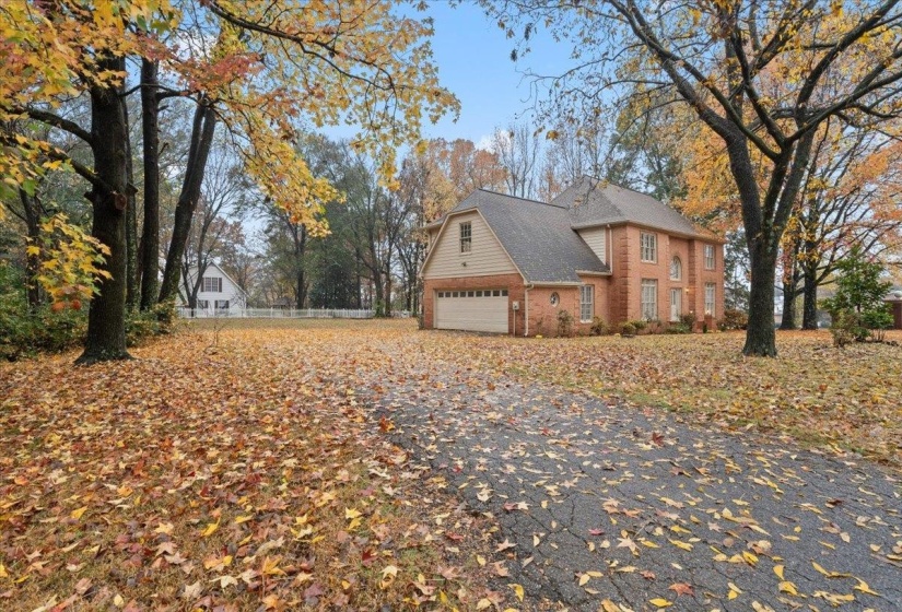View of side of home featuring a garage, driveway, and brick siding