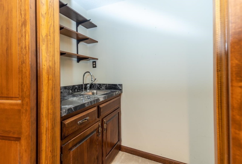 Bar with open shelves and dark brown cabinetry