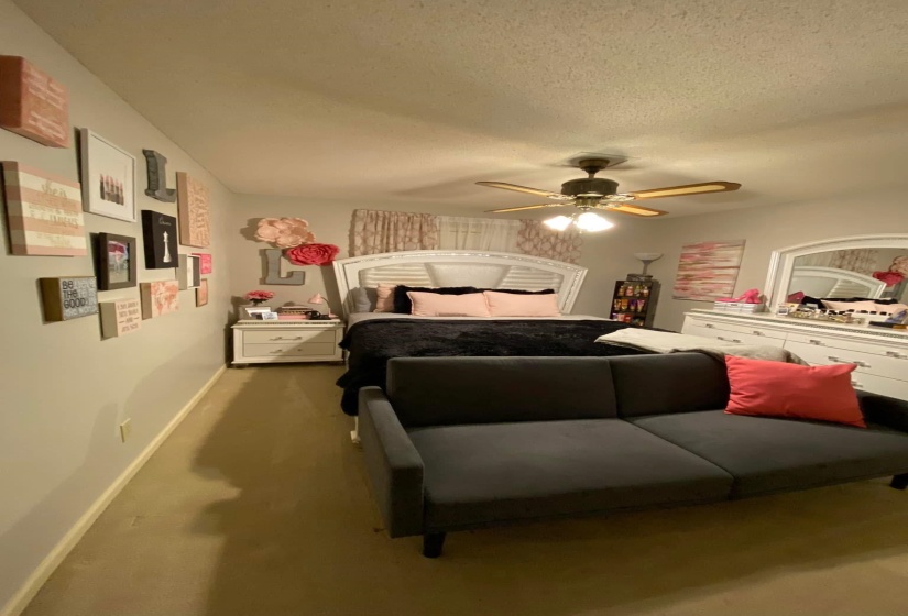 Bedroom featuring carpet flooring, a textured ceiling, and ceiling fan