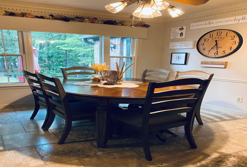 Dining area featuring stone tile flooring, a ceiling fan, and ornamental molding