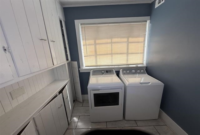 Laundry area with washer and clothes dryer and light tile patterned floors
