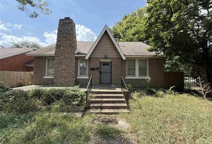 View of front facade with brick siding and a chimney