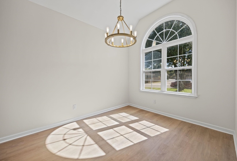 Unfurnished dining area featuring light wood-style floors, a chandelier, and lofted ceiling